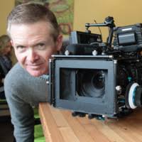 Dan Bärham posing behind a video camera